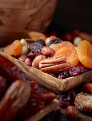 Various dried fruits and nuts in wooden dish.