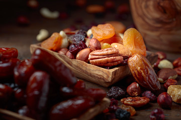 Various dried fruits and nuts in wooden dish.