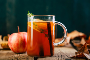 Apple tea with cinnamon, wooden background, retro rustic style, autumn mood