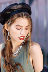 Top view of beautiful young model wearing dark cap and hair slides