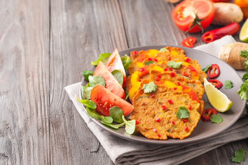 Indian chickpea crepes Pudla served on a plate with tomatoes, lime, cilantro, mash (mung bean)...