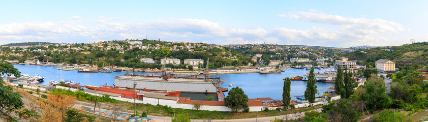 Panorama of Yuzhnaya bay in Sevastopol, Ships of the Black Sea Fleet of Russia and view to the factory and the city.