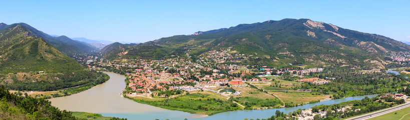Fototapeta na wymiar Panoramic view of Mtskheta, The Old Town Lies At The Confluence Of The Rivers Mtkvari And Aragvi. Svetitskhoveli Cathedral, Ancient Georgian Orthodox Church, Unesco Heritage In The Center.