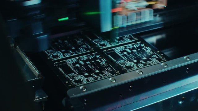 Factory Machine at Work: Printed Circuit Board Being Assembled with Automated Robotic Arm, Surface Mounted Technology Connecting Microchips to the Motherboard. Time Lapse Macro Close-up Footage.