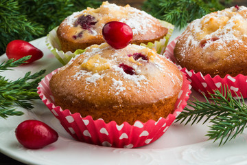 Cranberry muffins with ricotta on white plate on wooden table with Christmas decoration
