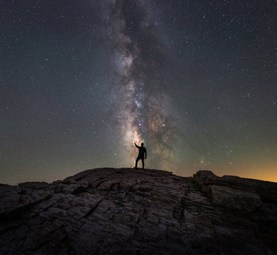 A Silhouette Of A Man Reaching For The Stars Of The Milky Way Galaxy 