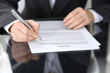 Close-up of female hands with pen over document of contact, business concept