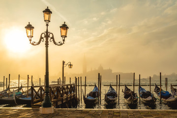 Plakaty  Gondole w Wenecji o wschodzie słońca z wyspą Saint Giorgio w porannej mgle, widziane z placu San Marco