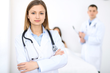 Medicine doctor standing and  smiling on the background with patient in the bed