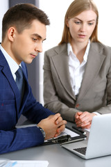 Fototapeta premium Business people using laptop pc while discussing project in office. Successful meeting and negotiation concepts