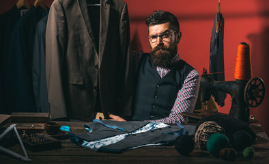 Fototapeta na wymiar Another client. sewing mechanization. suit store and fashion showroom. Bearded man tailor sewing jacket. business dress code. Handmade. retro and modern tailoring workshop. He got great style