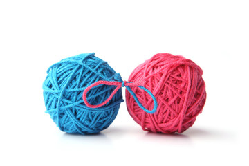 Two pink and blue cotton thread balls tied in bow isolated on white background.  Different color...