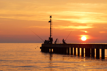 Fototapeta premium fishers in the sunset on the bridge