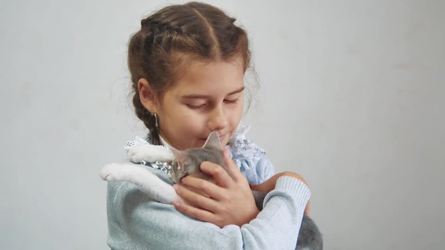 little girl holding a cat in her arms. kosh and girl pet friendship care and love. children and pets lifestyle cat concept