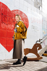 Fashion blogger wearing trendy bright oversize clothes posing for photo