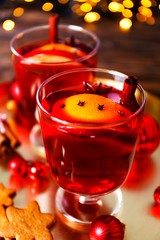 Christmas composition with mulled wine with its ingredients & spices on wooden textured table. Traditional drink on winter holiday season. Copy space, close up, top view, background.
