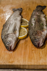 Rainbow trout fish on wooden table ready for cooking stuffed with lemon