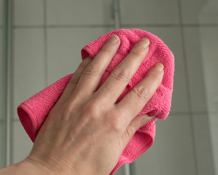 Hand beim reinigen einer Duschkabine