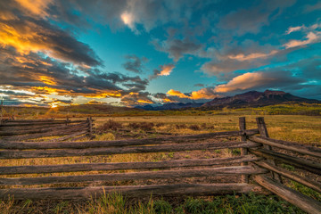 OCTOBER 3, 2018, RIDGWAY COLORADO USA - Sunrise on worm western fence in front of San Juan Mountains in Old West of Southwest Colorado near Ridgway - obrazy, fototapety, plakaty