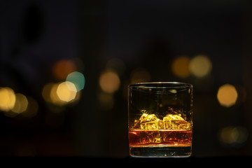 Whiskeyglas mit Eiswürfeln auf einer Bar