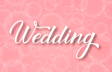Hand written calligraphy lettering Wedding with brush. Soft pink  background with bubblies bokeh.