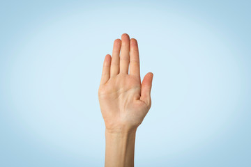 Female palm raised up on a blue background. Stop gesture. Concept stop someone, warn
