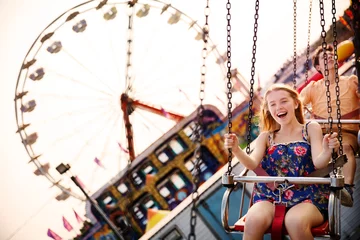 Fototapete Vergnügungspark Cheerful couple enjoying in chain swing ride at amusement park  © Cavan for Adobe