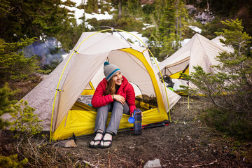 Happy woman looking away while sitting at tent © Cavan for Adobe
