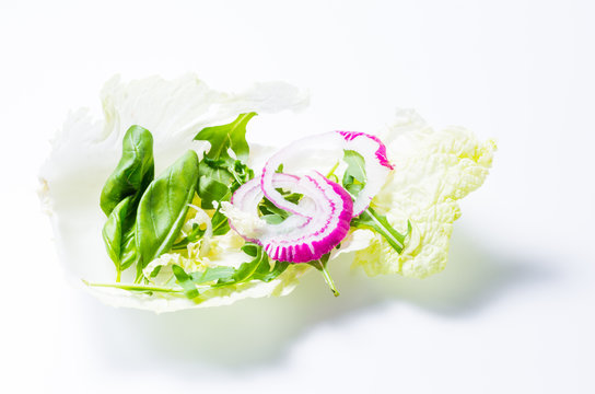 Eruca sativa and basil leaves on cabbage leaf.