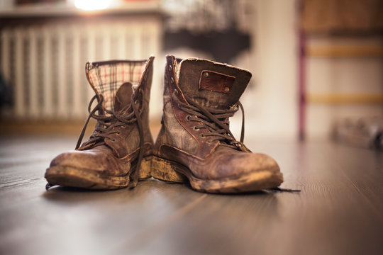 Close-up of dirty boots on hardwood floor at home