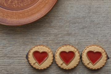 Heart shaped Valentines Day cookies with jam on dark wooden background. Top view. Copy space. Decorative background of heart. Design elements for Valentine's Day, Mother's day or Birthday