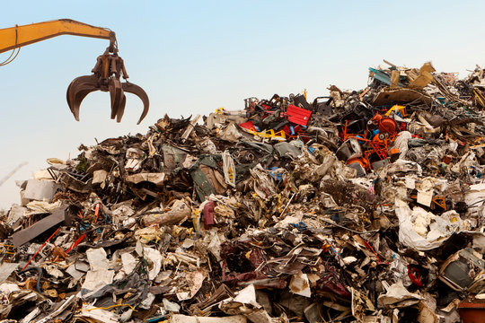 Cropped image of crane over garbage heap at junkyard