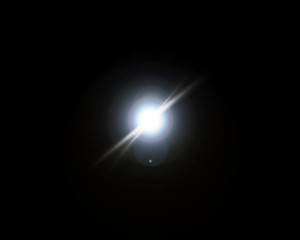 Isolated realistic lens flare visual effect on black night background. Space star. 