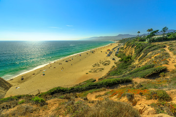 Aerial view of scenic Point Dume State Beach from Point Dume promontory on Malibu coast, Pacific Ocean in CA, United States. California West Coast. Blue sky, summer sunny day. Copy space.