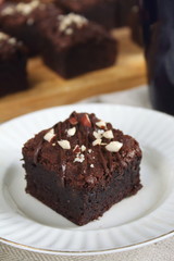Fototapeta na wymiar Chocolate fudgy brownie with nuts on white plate with spoon