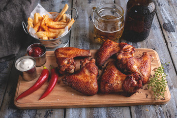 Grilled chicken wings, french fries, white and red sauce. Beer snack