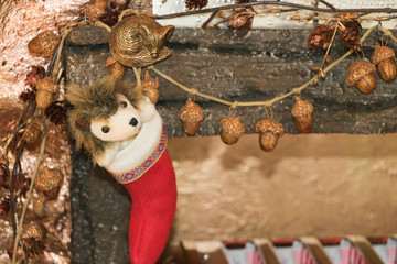 Traditional Christmas red sock for a gift is hanging on a wall with festive decorations of forest cute animals. Concept: preparing for winter holidays.