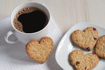Close-up of coffee and cookies in the shape of a heart