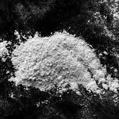 Isolated natural white flour powder texture effect on clean black background. Organic baking element close-up.