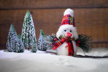 festive background. snowman dressed as Santa Claus with Christmas balls on light background photo has an empty space for your text