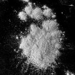 Isolated natural white flour powder texture effect on clean black background. Organic baking element close-up.