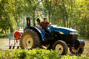 Farmer riding tractor on agriculture field © Cavan for Adobe