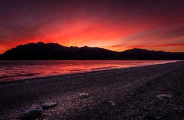 sunset over lake side mountains