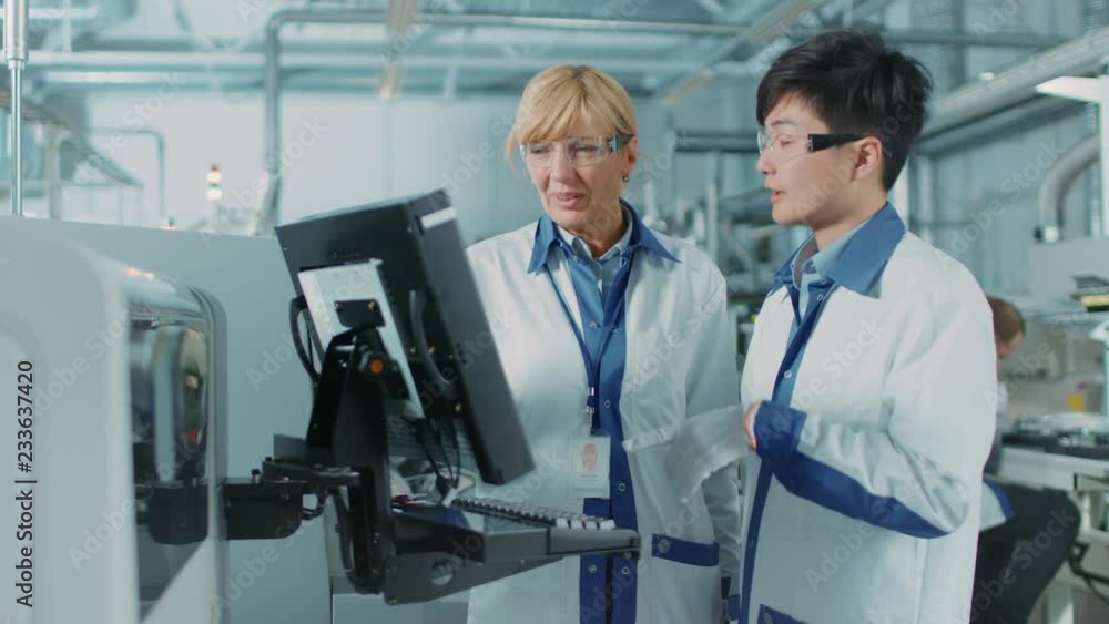 Poster on high tech factory asian engineer talks with female supervisor, use computer for programing pick a