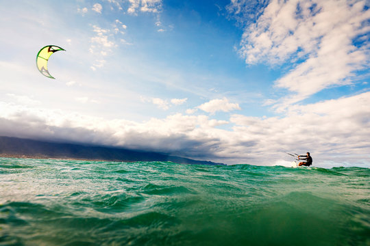 Man kiteboarding in sea against sky