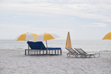 Beach and lounge chairs with umbrella for hotel guest resort reserved for sunny relaxing vacation day