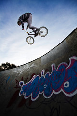 Low angle view of man performing stunt while cycling on sports ramp © Cavan for Adobe