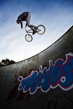 Low angle view of man performing stunt while cycling on sports ramp