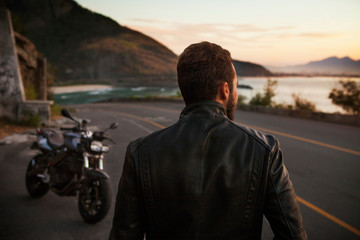 Rear view of man walking on coastal road during sunset © Cavan for Adobe