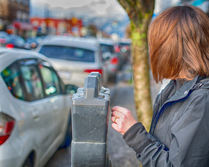 Woman pays for parking  by meter